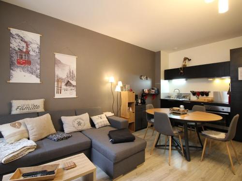 un salon avec un canapé et une table dans l'établissement Charmant T2 Bis au Mont-Dore, centre-ville, WIFI, à 100m des Thermes - FR-1-608-47, à Le Mont-Dore