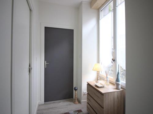 un couloir avec une porte, un bureau et une fenêtre dans l'établissement Charmant T2 Bis au Mont-Dore, centre-ville, WIFI, à 100m des Thermes - FR-1-608-47, à Le Mont-Dore