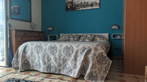 um quarto com uma cama e uma parede azul em Villa Giulia al Vesuvio em Trecase