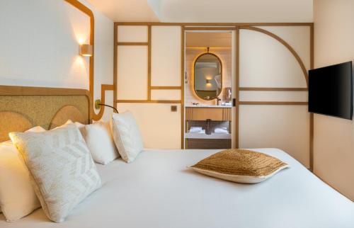 - une chambre avec un lit blanc et un miroir dans l'établissement Hôtel Le Monna Lisa by Inwood Hotels, à Paris