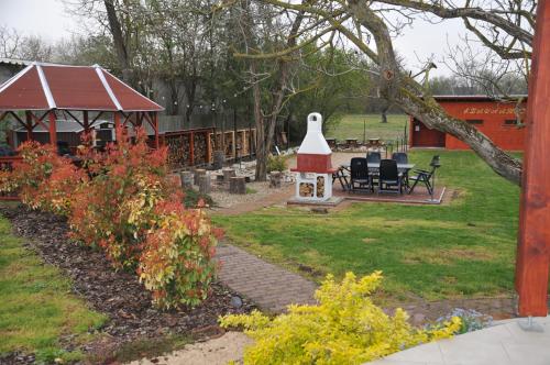 a garden with a bird house and a table and chairs at Casa Napsugár Panzió in Apostag