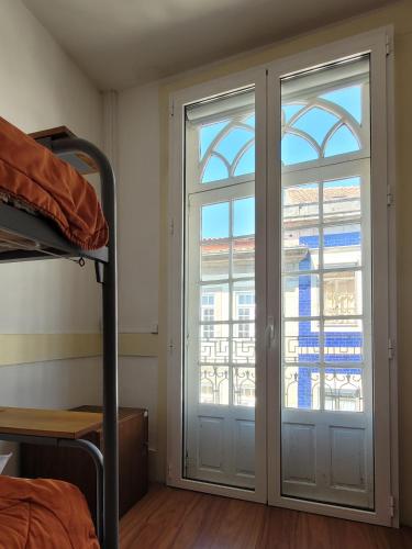 a room with a sliding glass door with a window at inBraga Hostel in Braga