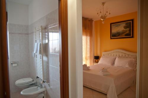um quarto com uma cama e uma casa de banho com um WC em B&BYanet's Beautiful House em Civitavecchia