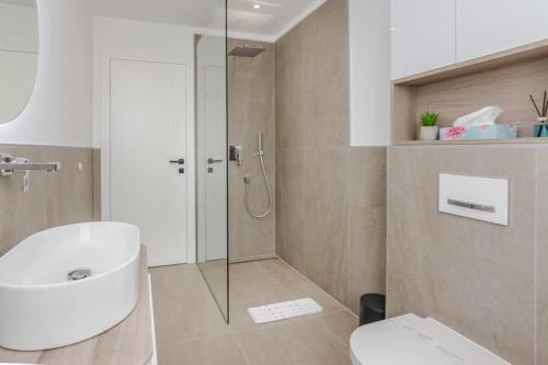 un bagno con doccia, lavandino e WC di Villa Ivani a Sukošan (San Cassiano)