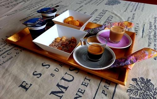 ein Tablett mit zwei Tassen Kaffee und einer Schachtel Essen in der Unterkunft VILLA AMA in Pordenone