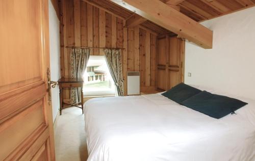 a bedroom with a white bed and a large window at Hôtel Le Labrador in Chamonix-Mont-Blanc