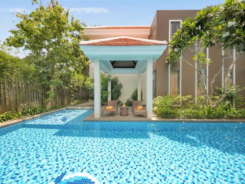 a swimming pool with a gazebo next to a house at Danang Ocean Resort & Spa Non Nuoc Beach Villas in Da Nang