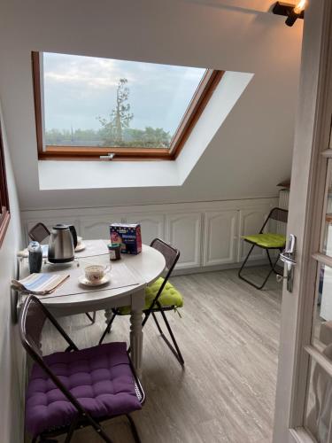 une table et des chaises dans une pièce avec une fenêtre dans l'établissement Appartement entier en résidence centre ville, à Vendôme