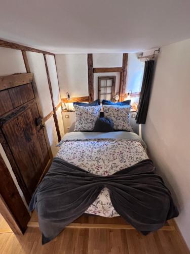 a bedroom with a large bed with blue pillows at Le Petit Cocon in Dambach-la-Ville
