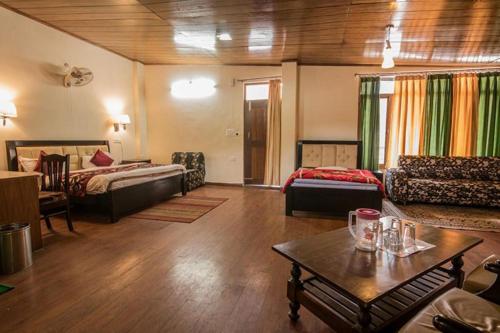 un ampio soggiorno con divano e tavolo di Hotel Moon by Excellent Hospitality a Nainital