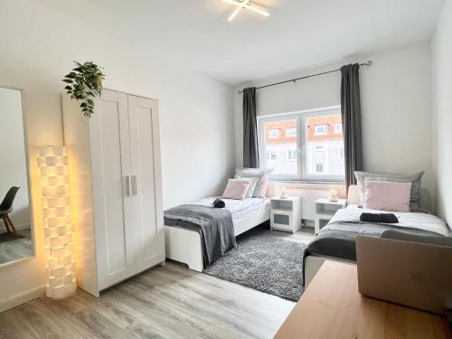 a bedroom with two beds and a window at Helle, gemütliche Ferienwohnung in Bremerhaven in Bremerhaven