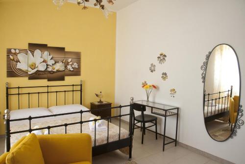 マンドゥーリアにあるMamma Luciaのベッドルーム1室(ベッド1台、鏡、テーブル付)