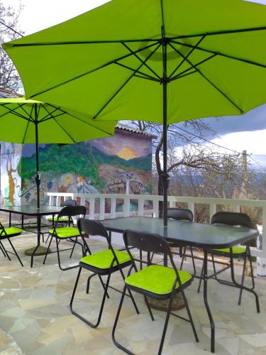 a group of tables and chairs with green umbrellas at Apartman SIRENA in Pićan