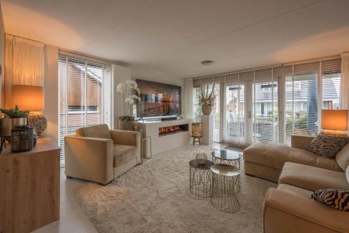 a living room with a couch and a table at Meerzicht 99 - Luxury house 30 minutes from Amsterdam in Uitgeest