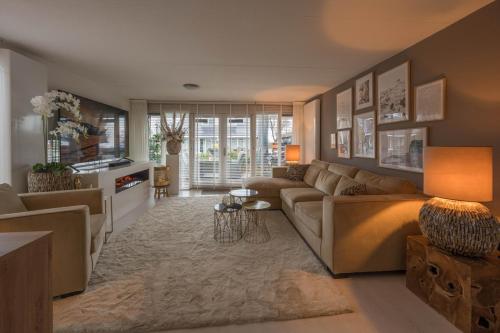 a living room with a couch and a table at Meerzicht 99 - Luxury house 30 minutes from Amsterdam in Uitgeest