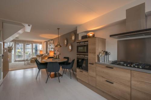 a kitchen with a table and a dining room at Meerzicht 99 - Luxury house 30 minutes from Amsterdam in Uitgeest