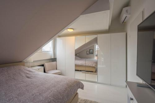 1 dormitorio con cama y espejo en Meerzicht 99 - Luxury house 30 minutes from Amsterdam, en Uitgeest