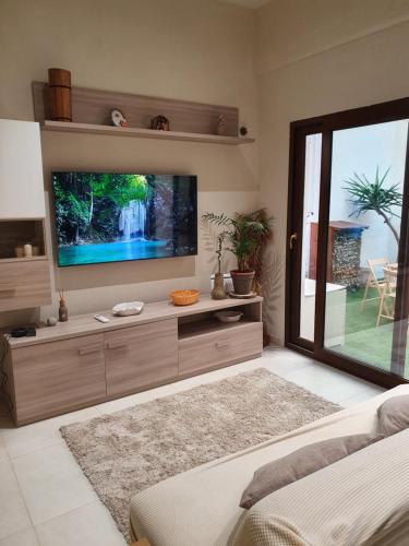 sala de estar con TV de pantalla plana grande en The Cube Best Vacation Ever, en Sinnai
