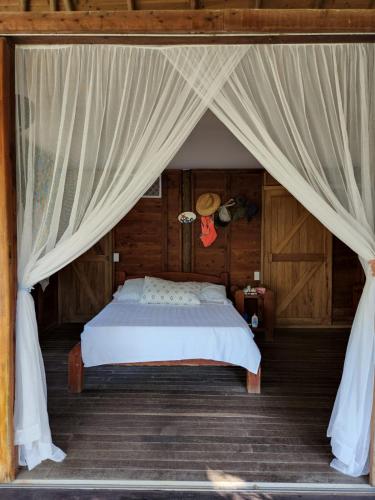 a bedroom with a bed with a canopy at Cabana Ferrer in Notecebes
