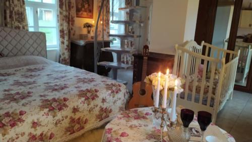 a bedroom with a bed and a table with candles at Jumpravas pils in Jumprava