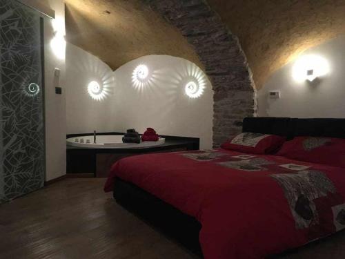 - une chambre avec un lit rouge et une baignoire dans l'établissement Lo Bòi Avise, à Avise