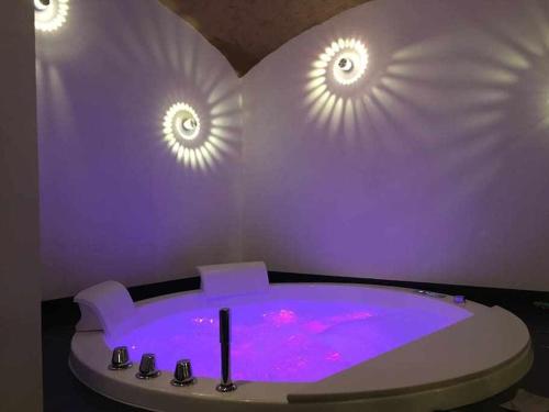 a purple room with a hot tub with lights on the wall at Lo Bòi Avise in Avise