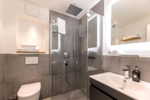 ein Bad mit einer Dusche, einem WC und einem Waschbecken in der Unterkunft Haus Andersen Apartment EINS in Norderney