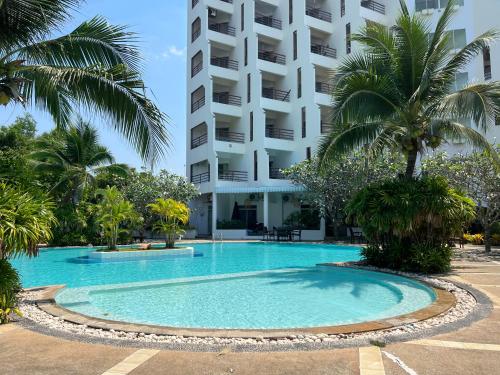 a swimming pool in front of a building at sea sand sun resort Executive Mae Rumphueng beach in Rayong