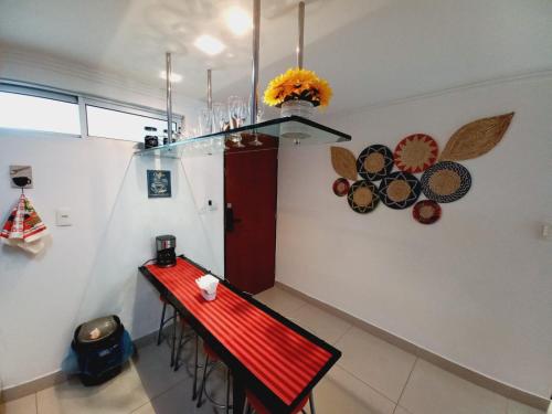Habitación con una mesa roja con sillas y una barra roja. en Cabo Branco Dream, en João Pessoa