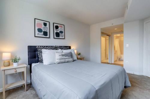 a bedroom with a large white bed and a table at Fantastic 1 Bedroom Condo At Ballston With Gym in Arlington