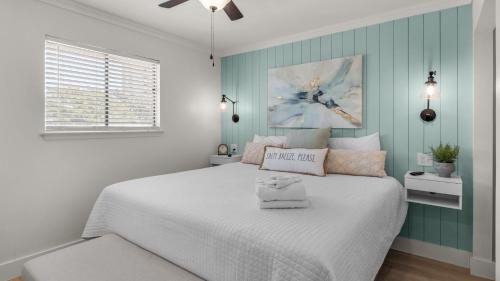 Beachside Condo 21 في شاطئ سانتا روزا: غرفة نوم بسرير أبيض وجدار أزرق