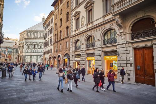 eine Gruppe von Menschen, die eine Stadtstraße entlang laufen in der Unterkunft Firenze Rooms Cathedral B&B in Florenz