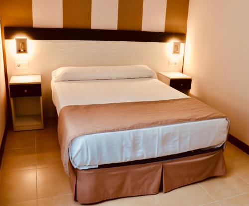 1 dormitorio con 2 camas y 2 mesitas de noche en Playa Home Helgueras con acceso a Spa (AguaMarinaSpa) en Noja