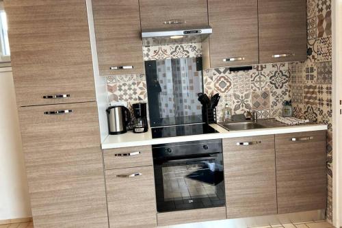 una cucina con piano cottura e lavandino di Le Saint-Amour appartement classé 2 étoiles a Saint-Amour