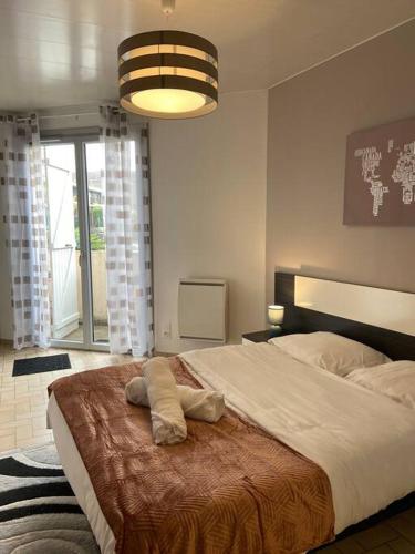 une chambre avec un grand lit et une grande fenêtre dans l'établissement Le Saint-Amour appartement classé 2 étoiles, à Saint-Amour