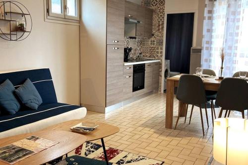 un soggiorno con divano blu e tavolo di Le Saint-Amour appartement classé 2 étoiles a Saint-Amour
