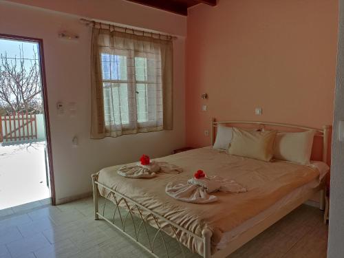a bedroom with a bed with two roses on it at Zorbas Rooms in Frangokastello