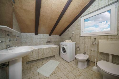 W łazience znajduje się umywalka i pralka. w obiekcie Apartments Mićin w mieście Vodice