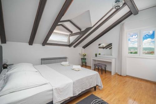1 dormitorio con 1 cama, escritorio y ventanas en Apartments Mićin, en Vodice