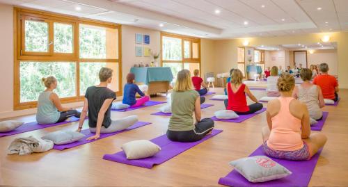 a group of people sitting in a yoga class at Résidence Club mmv L'Étoile des Cimes **** in Sainte-Foy-Tarentaise