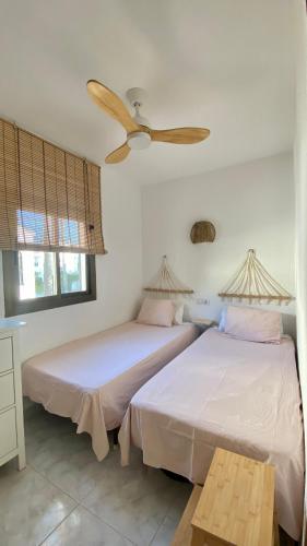 two beds in a bedroom with a ceiling fan at Casita Pepe in Jávea