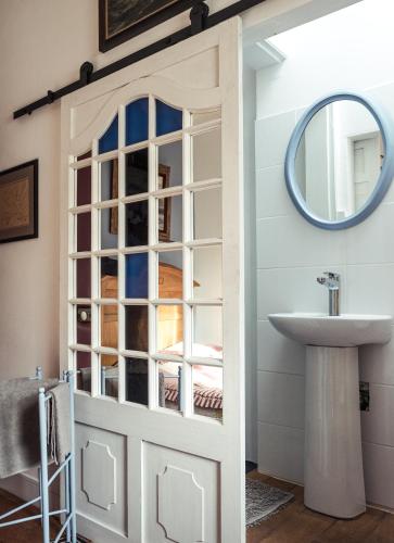 La salle de bains est pourvue d'une porte avec un lavabo et un miroir. dans l'établissement Chambres d'hôtes Villa l'espérance, à Étretat