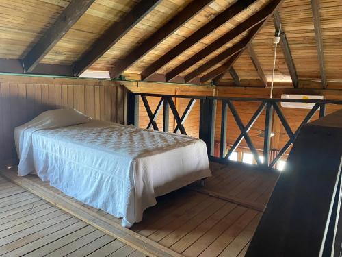 1 dormitorio con 1 cama en una cabaña de madera en CASA PARAISO, en Puerto Morelos