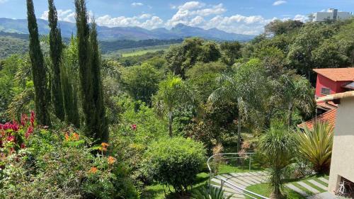 ブルマジーニョにあるPousada Verde Villasの木々と家の庭園を望む