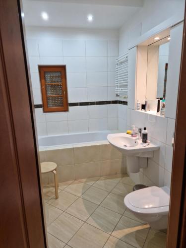 La salle de bains est pourvue de toilettes, d'un lavabo et d'une baignoire. dans l'établissement Siedem C, à Pobierowo