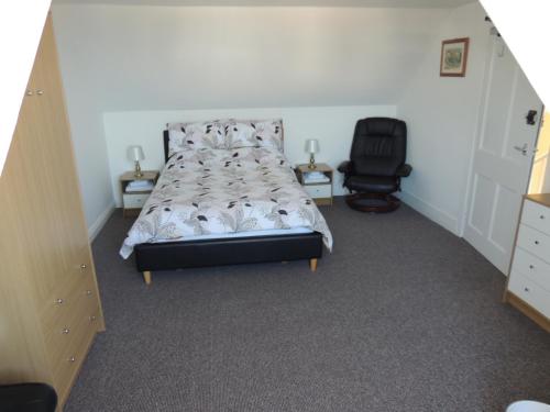 a bedroom with a bed and a desk and a chair at 5A Union Road in Macduff