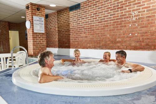 un groupe de personnes dans un bain à remous dans l'établissement 2 Bed Chalet St Margaret's at Cliffe South Coast, à Douvres