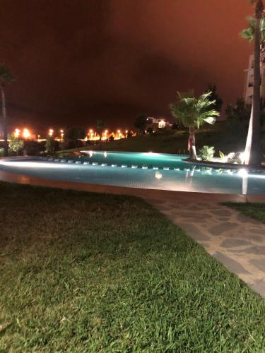 a bench with lights on the grass at night at Lilacs Garden Cabo in M'diq