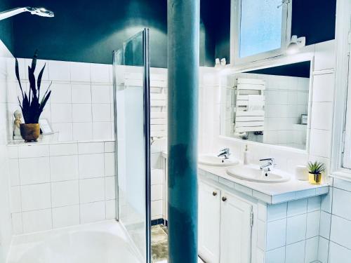 ein Badezimmer mit zwei Waschbecken und einer Glasdusche in der Unterkunft Luxury Place in Le Marais - Central Paris in Paris
