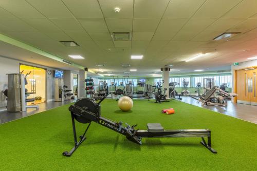 a gym with a treadmill and a ball on a green rug at Pillo Hotel & Leisure Club in Ashbourne